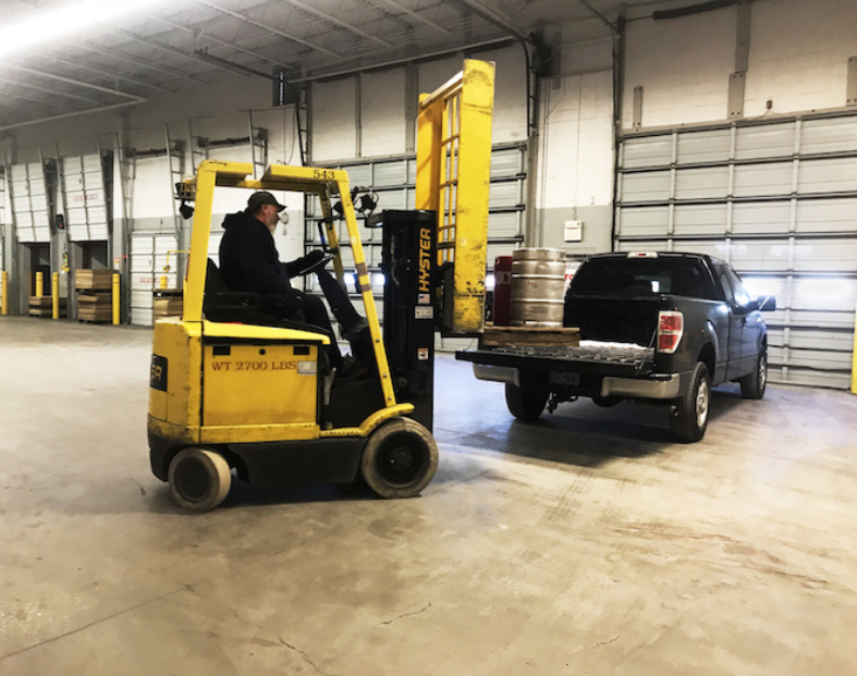 Forklift loading keg onto truck